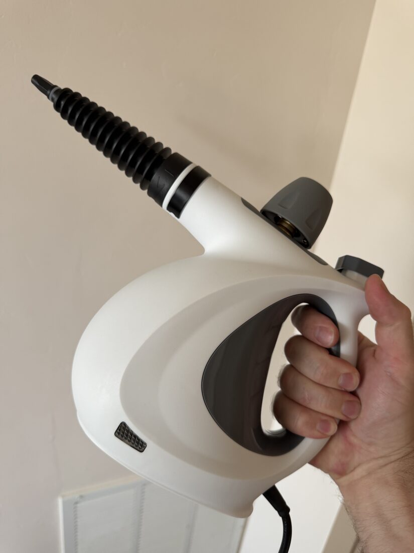 Velmora handheld steam cleaner held in hand